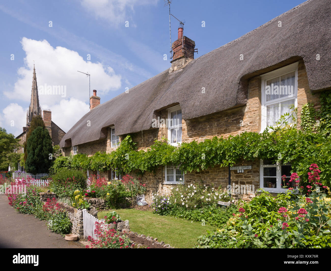 Reetgedeckte Cottages mit St. Peter und St. Paul's Kirche, Könige Sutton, in der Nähe von Banbury, Northamptonshire, England, Grossbritannien, Europa Stockfoto