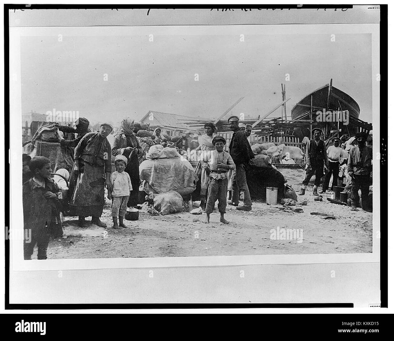 Foto, das armenische Flüchtlinge am Schwarzmeerstrand in Noworossiisk, Russland, mit Haushaltsbesitz und Dokumentation der Flüchtlingserfahrung während einer Konfliktphase zeigt. Stockfoto
