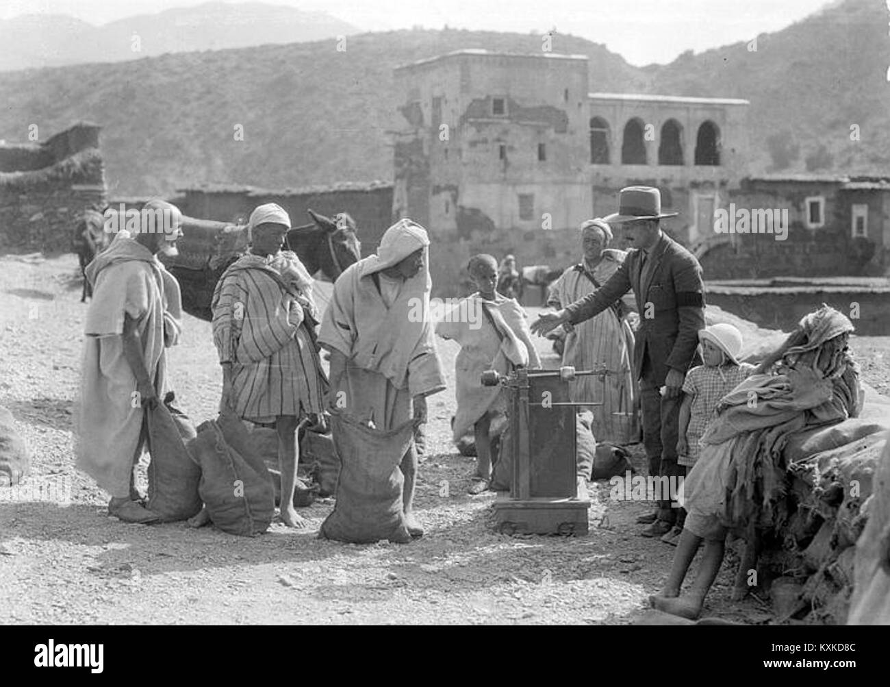 Ein historisches Foto, das die Ankunft von Bleierz aus der Mine Takhbart in Tagadir, Marokko, um 1925 zeigt und Bergbaubetrieb und Transportmethoden veranschaulicht. Stockfoto