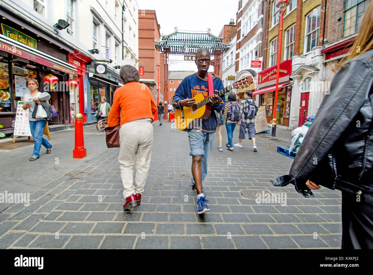 London, England, UK. Der Mann mit der Gitarre, Gerrard Street in Chinatown Stockfoto