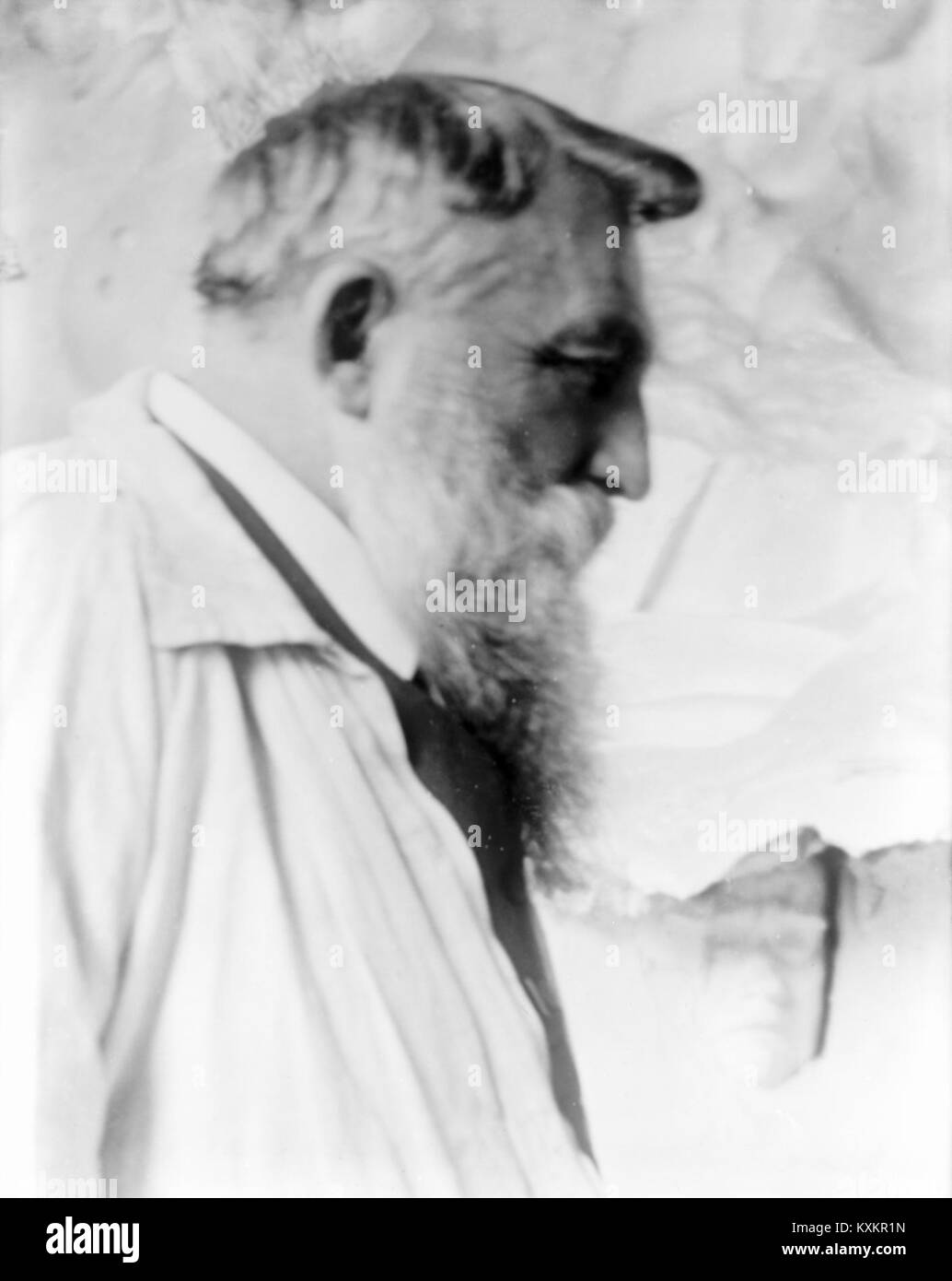Eine Fotografie aus dem Jahr 1905 zeigt Auguste Rodin, den französischen Bildhauer, in einer reflektierenden Pose, aufgenommen von dem Fotografen Gertrude Késebier. Das Bild unterstreicht Rodins kontemplativen Ausdruck und die Kunstfertigkeit von Késebiers Porträtfotografie. Stockfoto