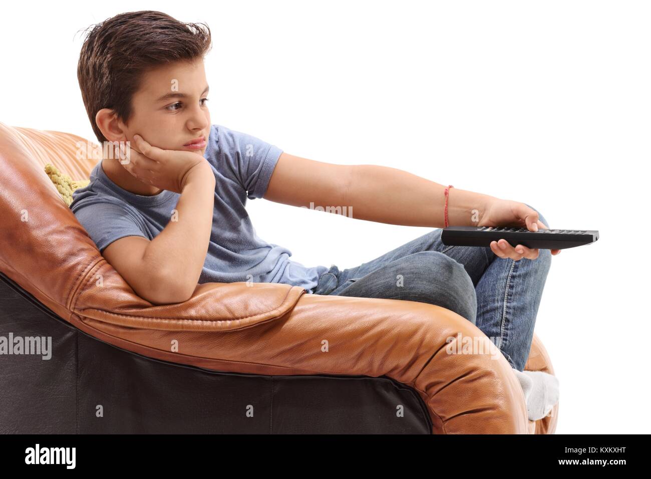 Langweilig Junge in einen Sessel Fernsehen auf weißem Hintergrund sitzt Stockfoto