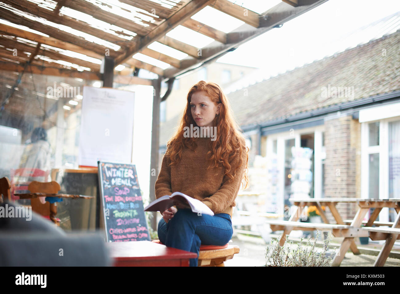 Frau im Café holding Notebook suchen Feierliche Stockfoto