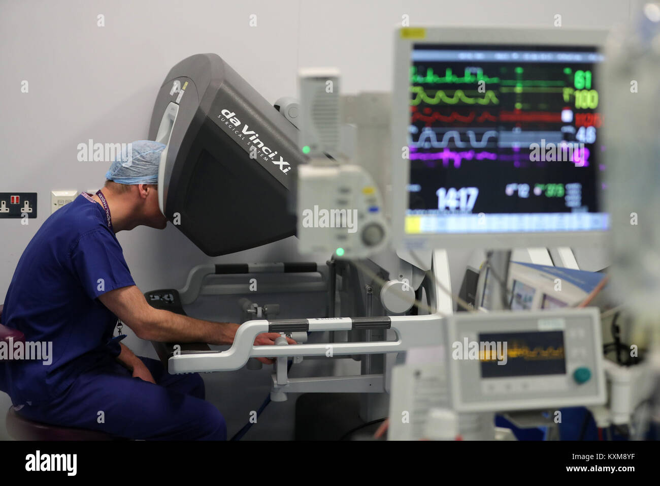 Der Herzog von Cambridge schaut durch ein Dual Console des Da Vinci Roboter während führen Chirurg Vin Paleri (Frame) führt eine Robotic assisted Deichsel hemiglossectomy Chirurgie auf Patienten Anne Weiß, 67, bei seinem Besuch im Royal Marsden NHS Foundation Trust in London. Stockfoto