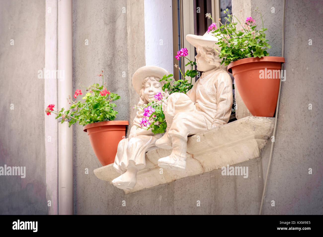 Fensterbänke Statuen Kinder Hintergrund Blumentöpfe balkon Fensterbank Stockfoto