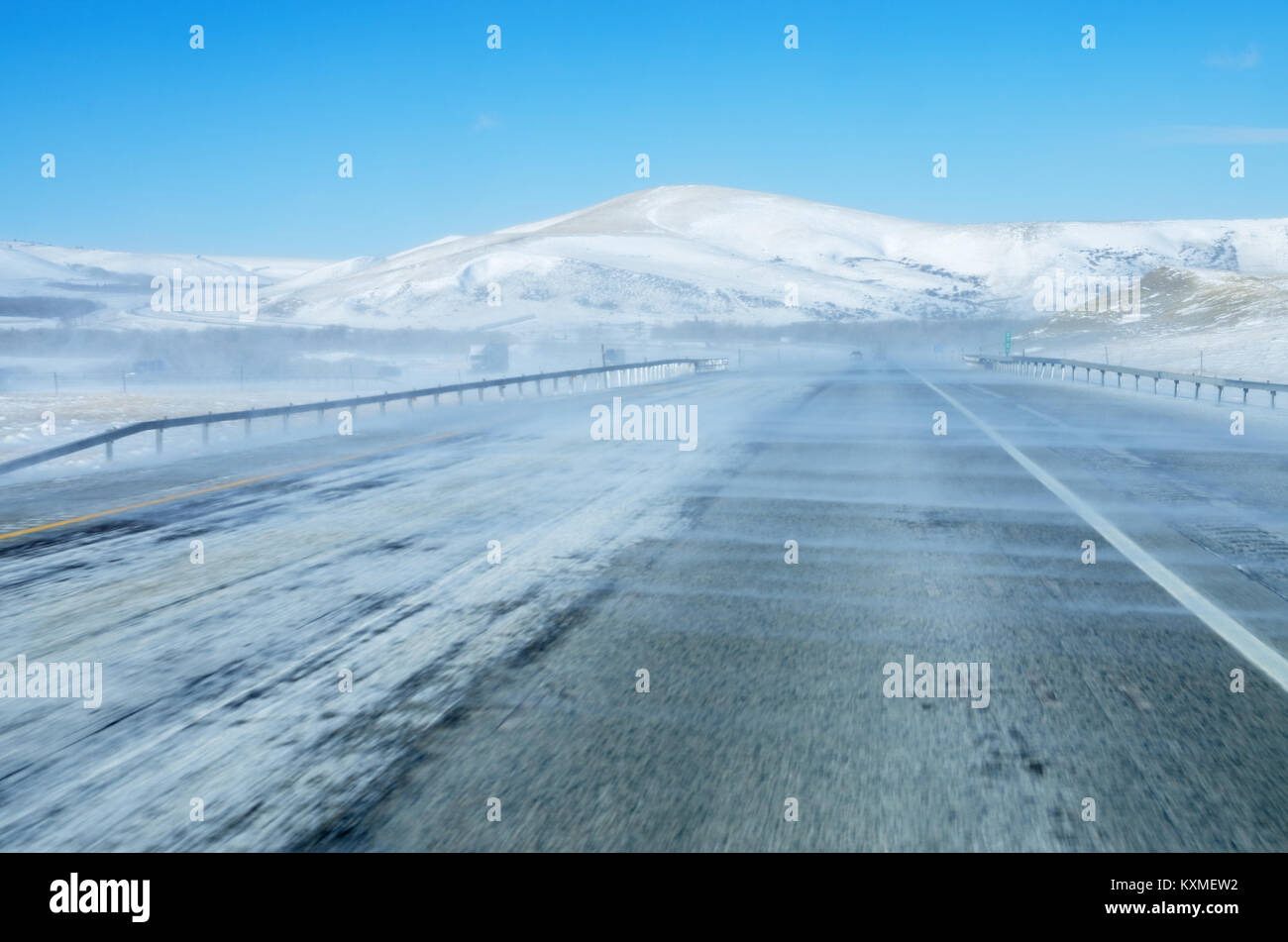 Schneefräsen auf der Interstate 80 Autobahn in Wyoming Reduzierung der Sichtbarkeit mit blauer Himmel über Stockfoto