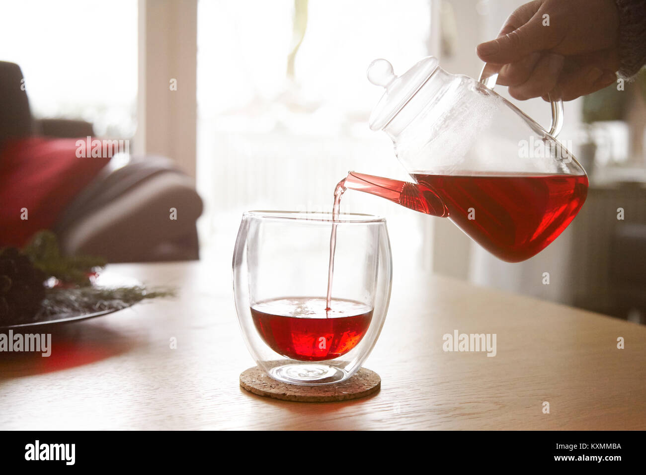 Frau gießen roter Tee in Glas Stockfoto
