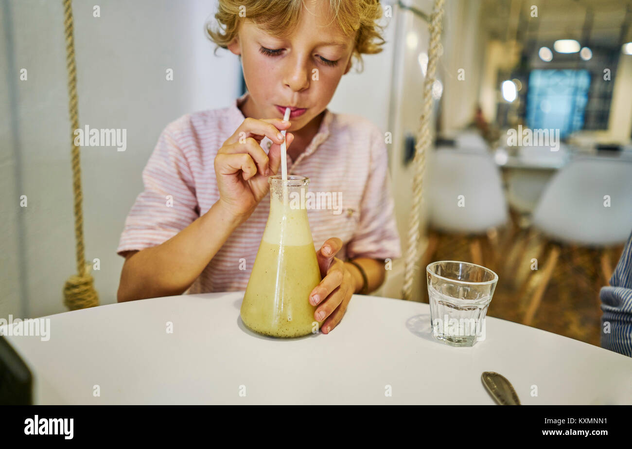 Junge Saft trinken durch Stroh Stockfoto