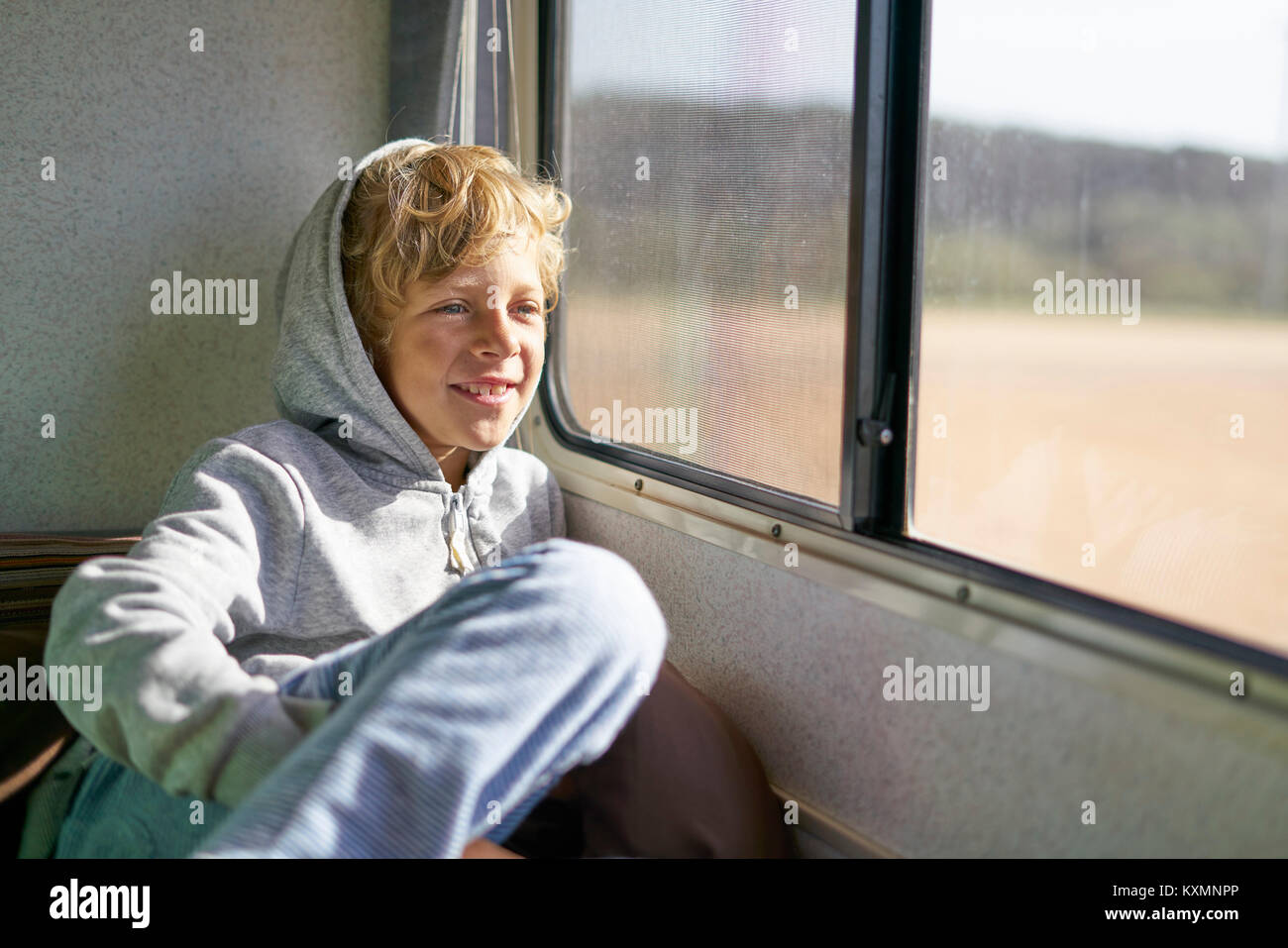 Junge sitzt im Wohnmobil Blick aus Fenster, Polonio, Rocha, Uruguay, Südamerika Stockfoto