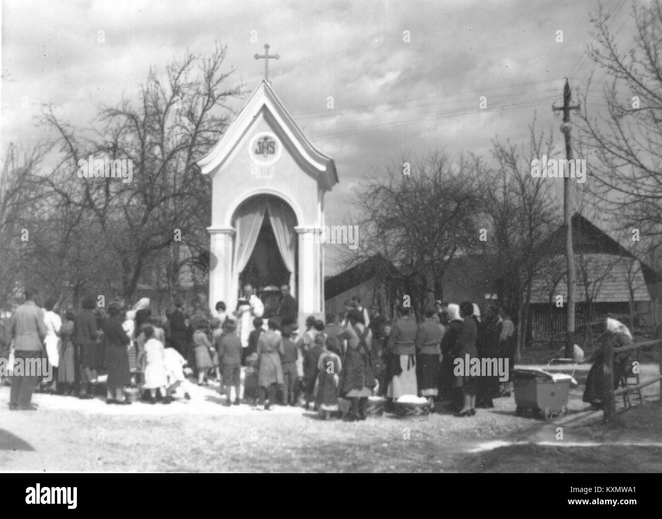 Eine religiöse Zeremonie, bei der Osterspeisen vor einer Kapelle gesegnet werden, die traditionelle christliche Praktiken und Feiertage symbolisiert. Stockfoto