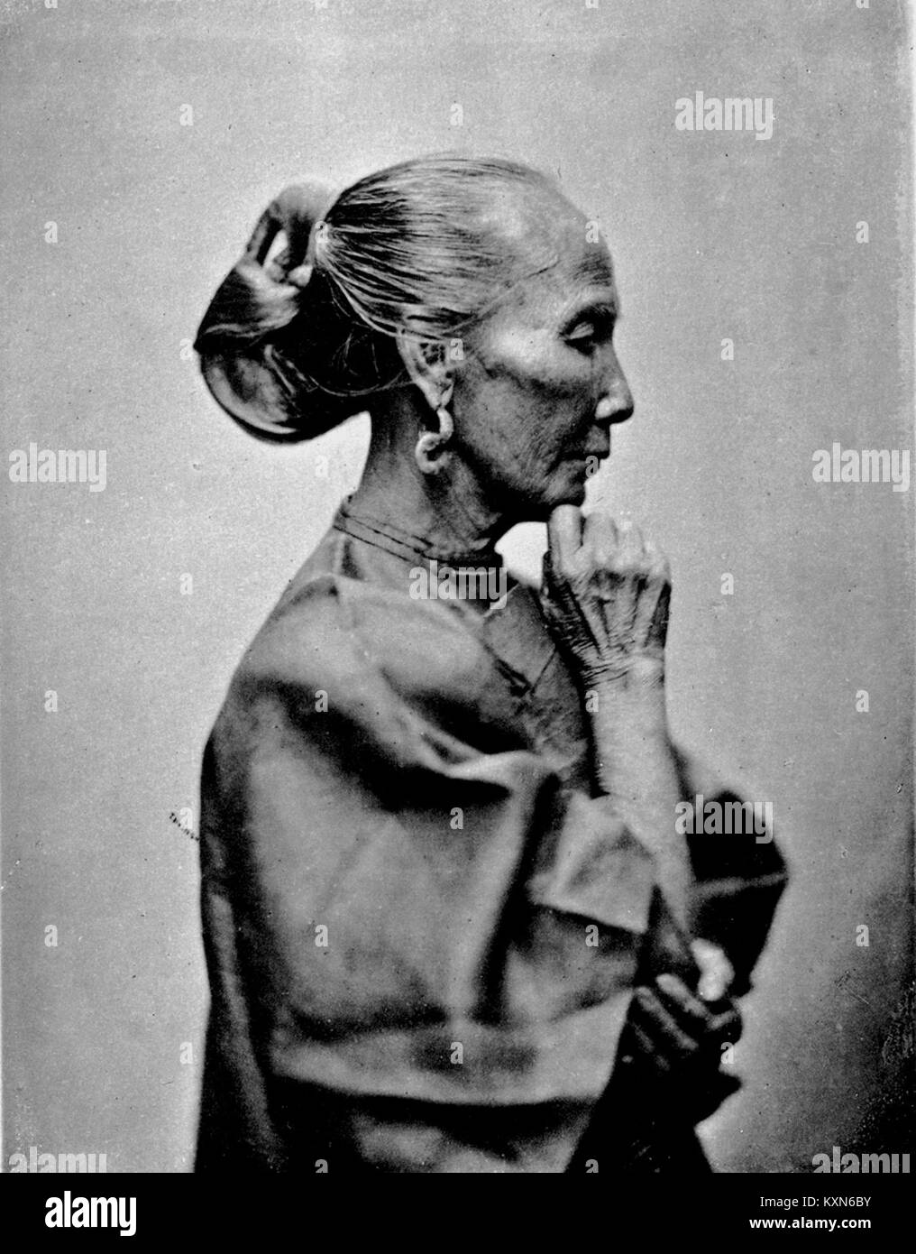 Ein Foto zeigt eine ältere Frau und hebt Aspekte des Alters, des Aussehens und der traditionellen Kleidung in einer natürlichen oder häuslichen Umgebung hervor. Stockfoto