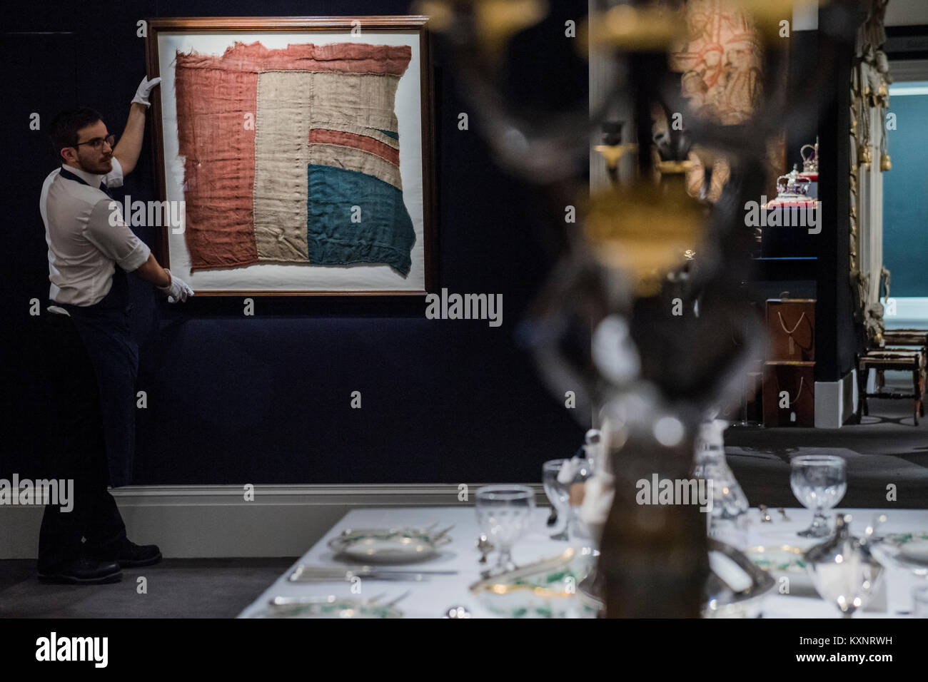 London, Großbritannien. 11. Januar, 2018. Ein großer Rest der HMS Victory Union Jack aus der Schlacht von Trafalgar est. £ 80.000, die im Hintergrund von anderen Verkauf Einzelteile einschließlich einer Büste von Nelson und einige seiner Tischgeschirr -100,000 - Sotheby's London" Der königliche und adelige Abstammung" Verkauf umfasst über 250 königliche und adelige Erbstücke, einschließlich einer Kopie der Britischen Kronjuwelen. Das Ensemble von Möbeln, Gemälden, die dekorativen Künste und wertvolle Objekte auctionedon vom 17. Januar 2018. Credit: Guy Bell/Alamy leben Nachrichten Stockfoto