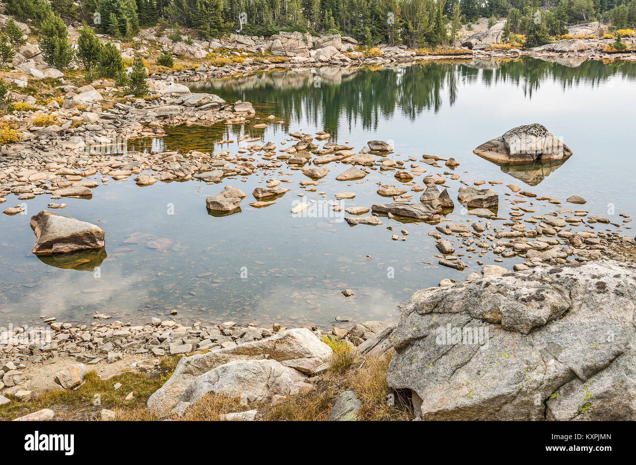 Ruhige See mit Felsen und schöne Reflexionen entlang der Beartooth Highway Stockfoto