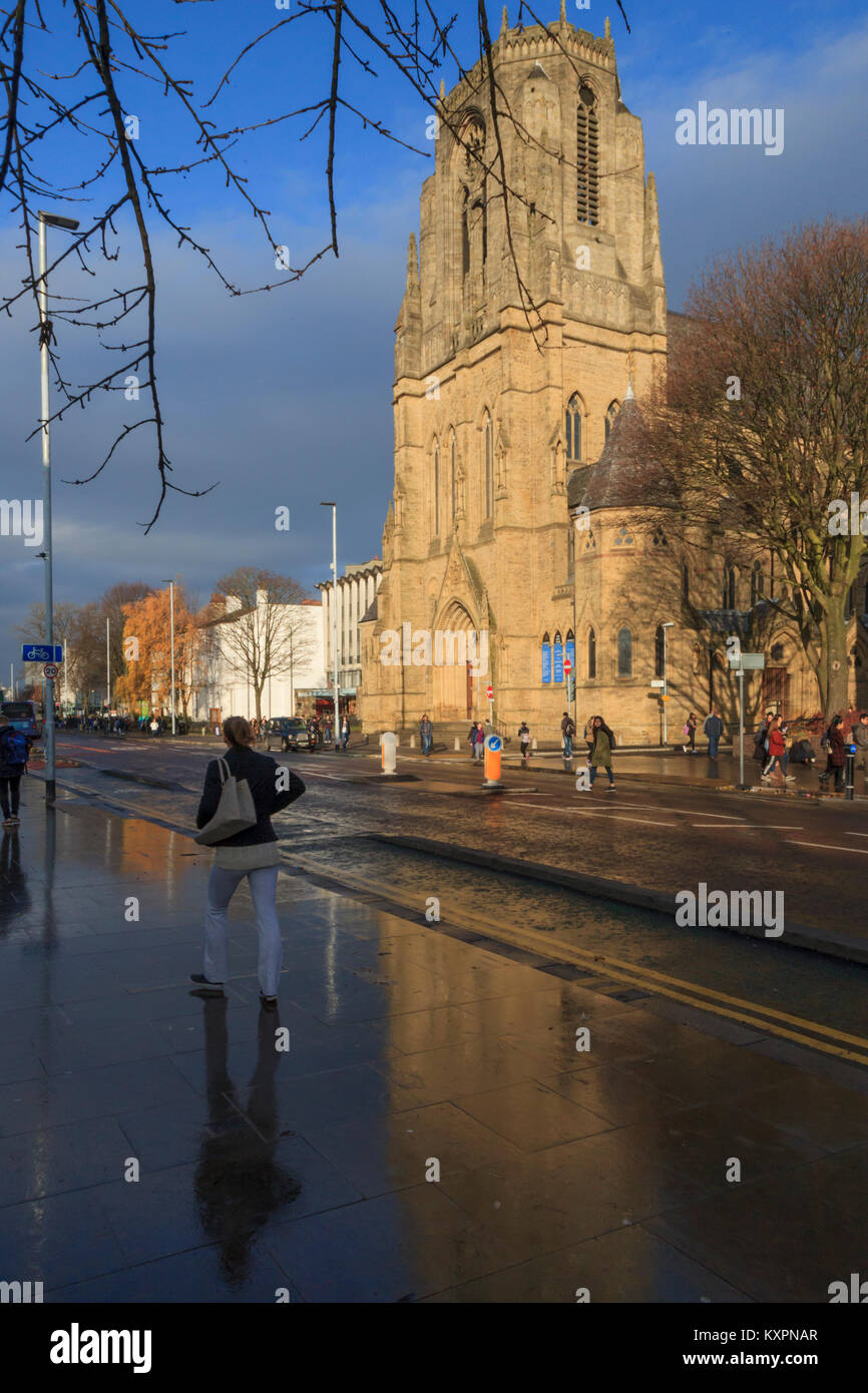 Die Heiligen Namen Kirche, die sich auf nasser Fahrbahn reflektierte, Oxford Road, Manchester, UK Stockfoto