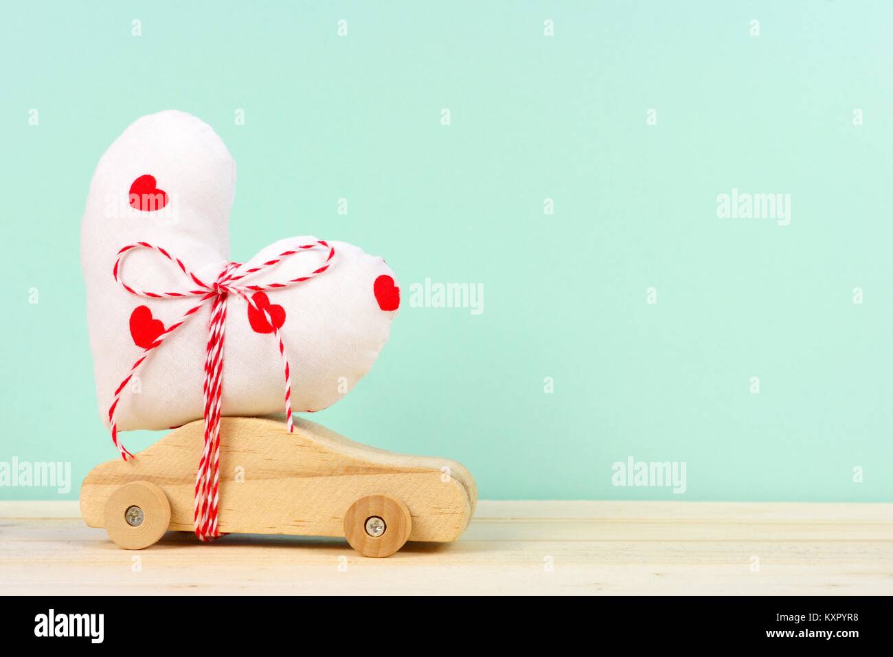 Holzspielzeug mit hausgemachten Herzen Geschenk gegen einen türkisen Hintergrund. Valentines Tag oder Liebe Konzept. Stockfoto