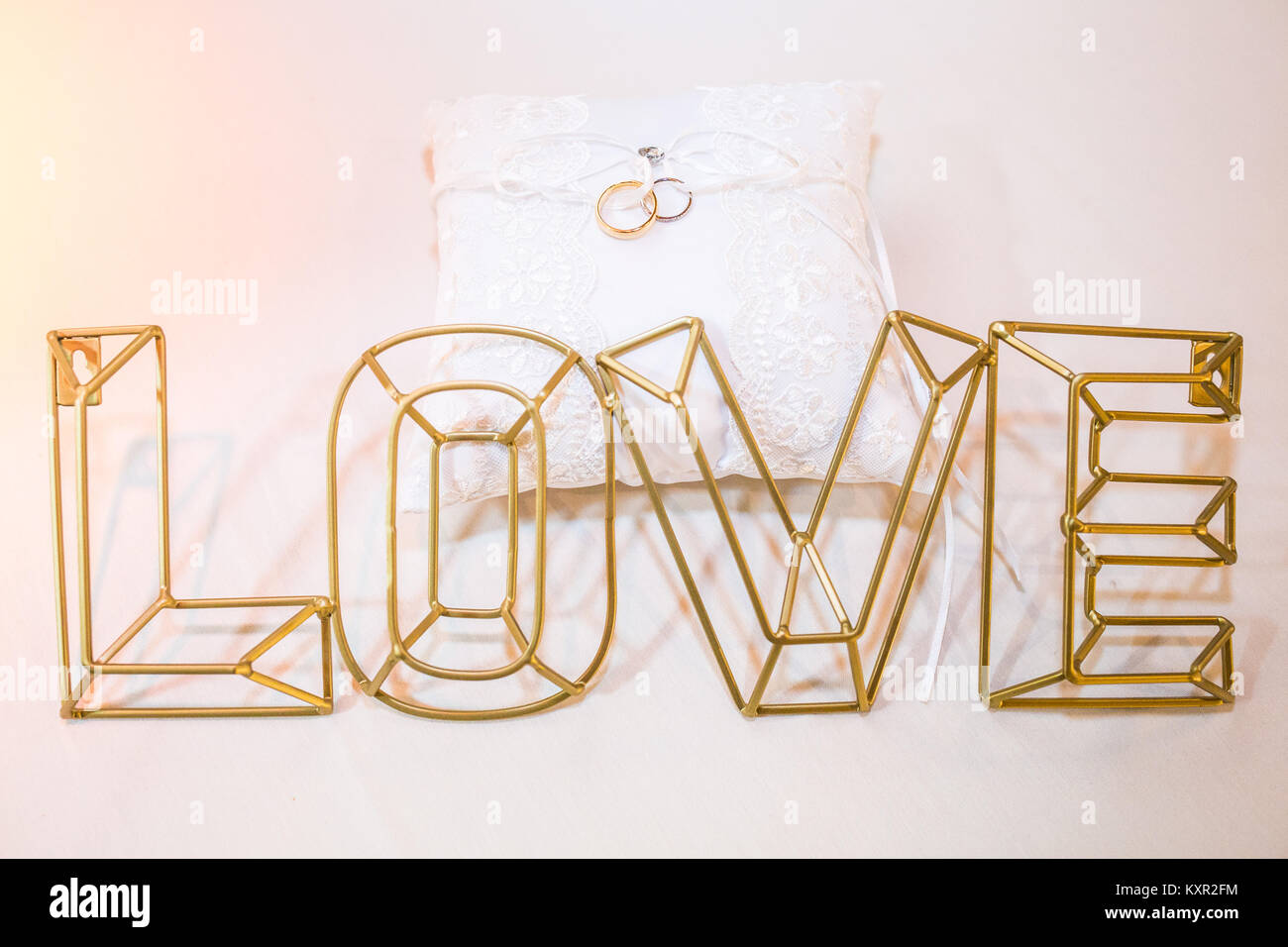 Zwei Trauringe auf einem weißen Kissen Nahaufnahme mit Liebe Stockfoto