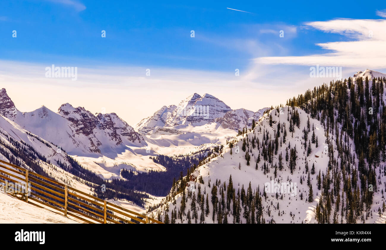 Schöne Aussicht von Kastanienbraun Bell Skigebiet in Snowmass, Colorado; Holzzaun auf der linken, blauen Himmel mit Wolken über Stockfoto