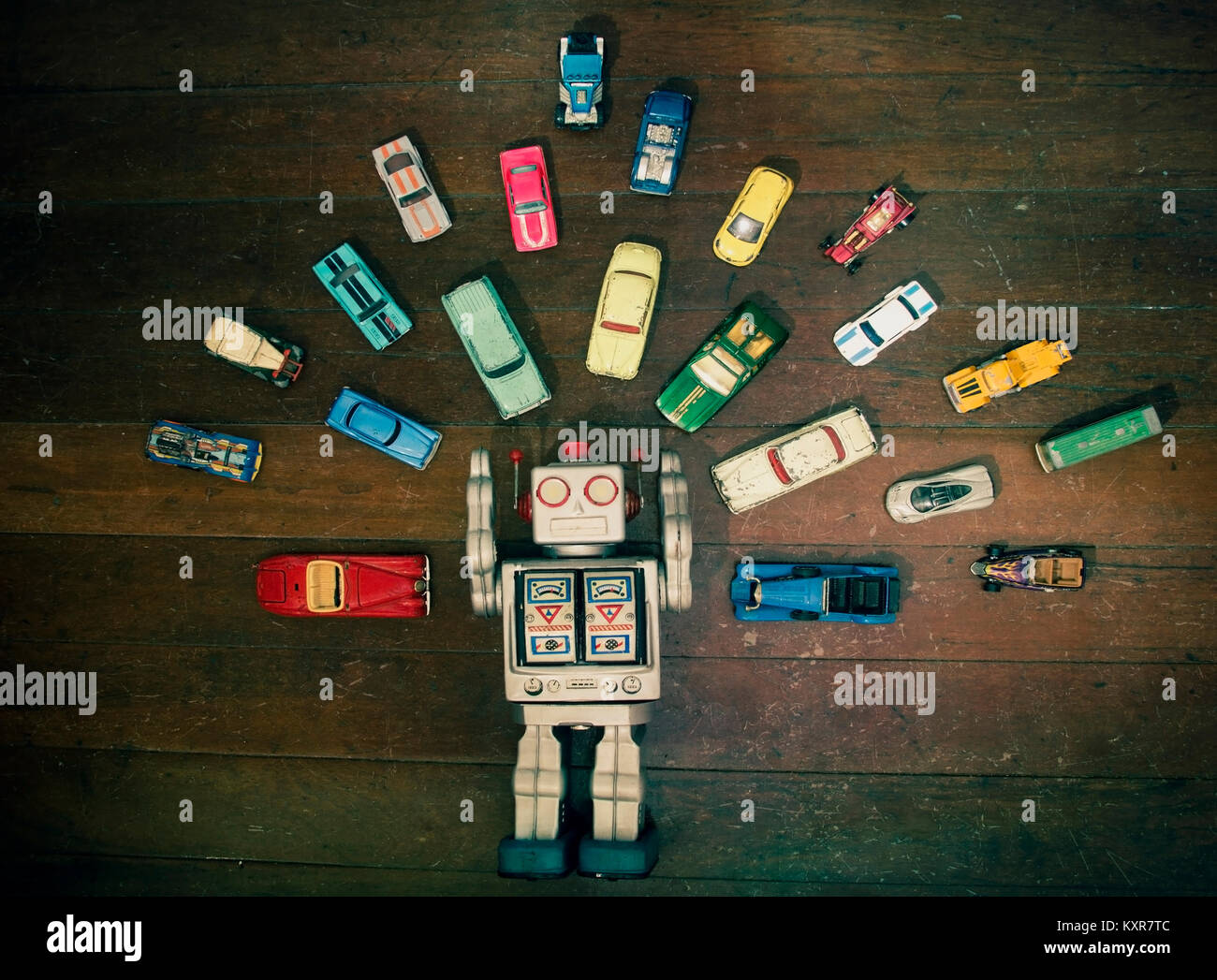 Vintage Roboter Spielzeug umgeben von viel retro Metall Spielzeugautos Stockfoto