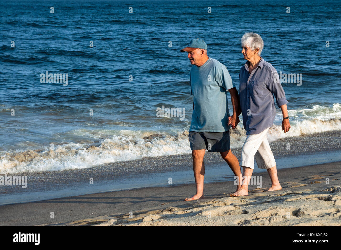 Senior Paar zu Fuß am Strand entlang. Stockfoto