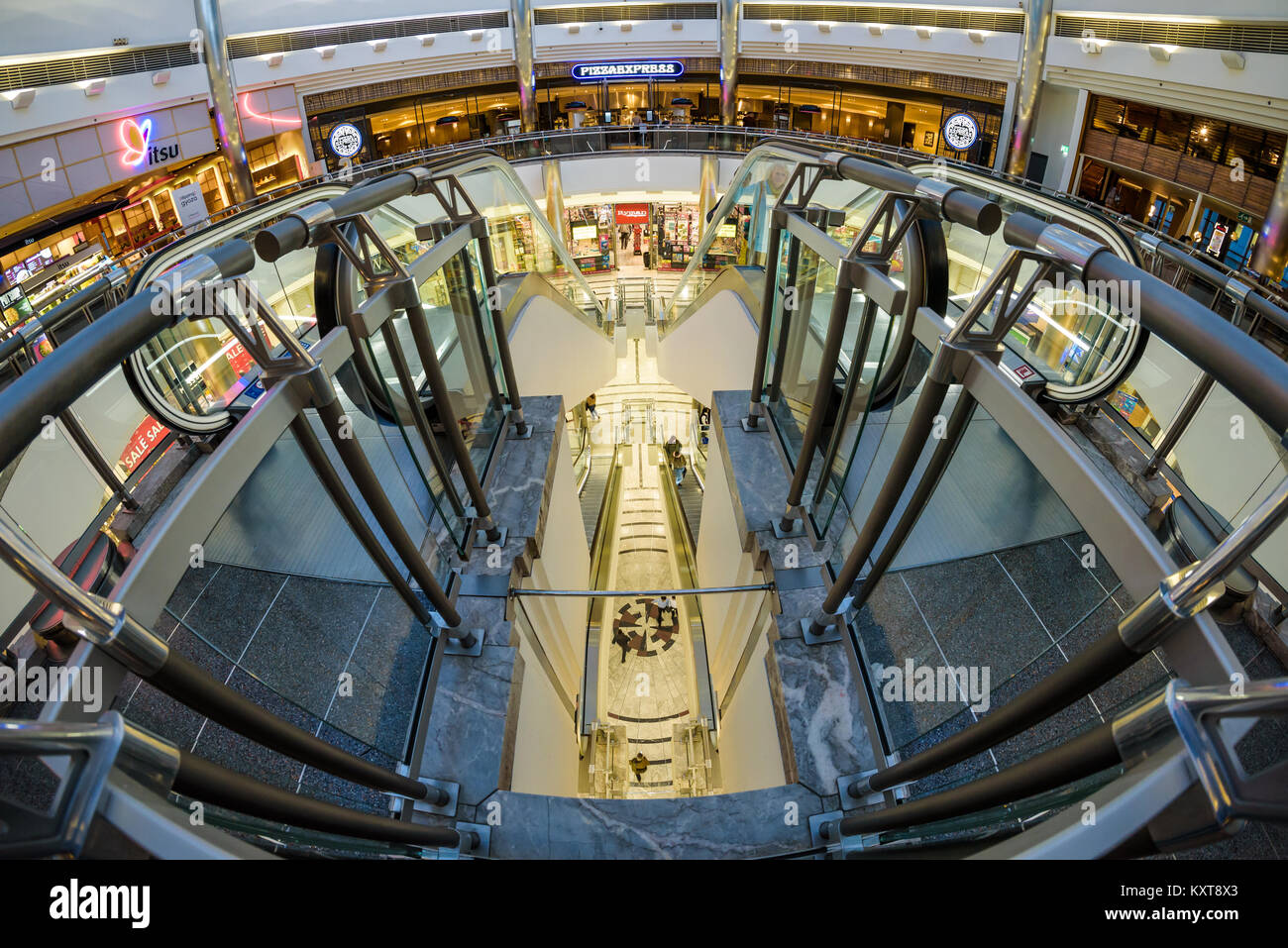 Canary Wharf Einkaufszentrum unter Glaskuppel und Wolkenkratzer 1 Canada Square. Cabot Square, Leute auf Rolltreppen, Geschäften und Restaurants. Stockfoto