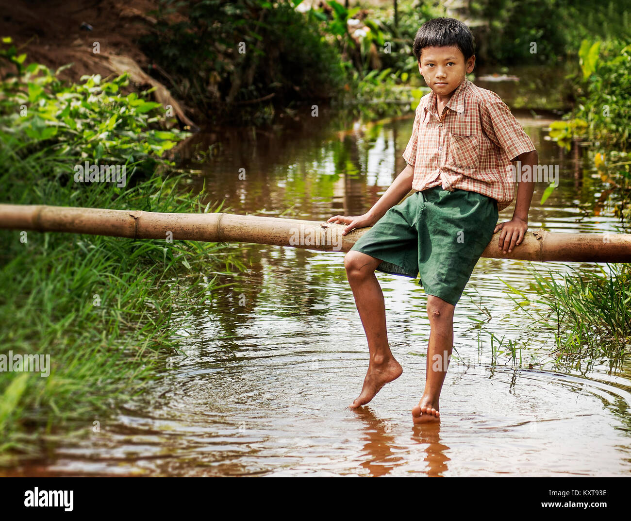 Little Boy entspannen in einem Teich nach der Schule in Yangon, Myanmar Stockfoto