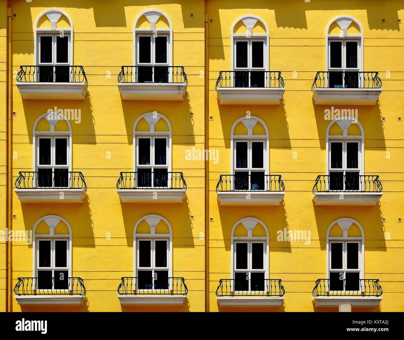 Dramatische Schatten auf die gelbe Fassade eines klassischen Town House in Singapur Stockfoto
