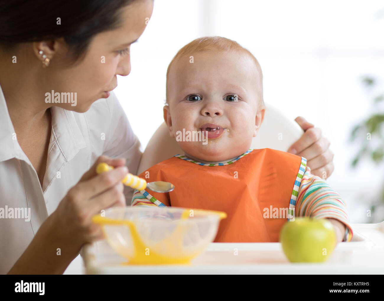 Mutter füttert ihr Kind. Baby weint, launisch und weigert zu essen Stockfoto
