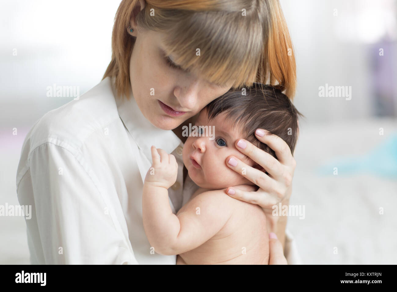 Sorgfältige Mutter ihr neugeborenes Baby Tochter umarmen Stockfoto