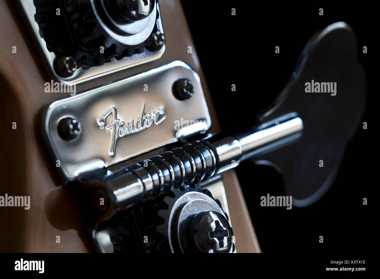 Badewanne, Großbritannien, 13. Mai 2011: Fender Marke in einem Metallgehäuse jagte Tuning peg auf einem Jazz Bass Gitarre mit einem schwarzen Hintergrund. Makro Nahaufnahme Stockfoto