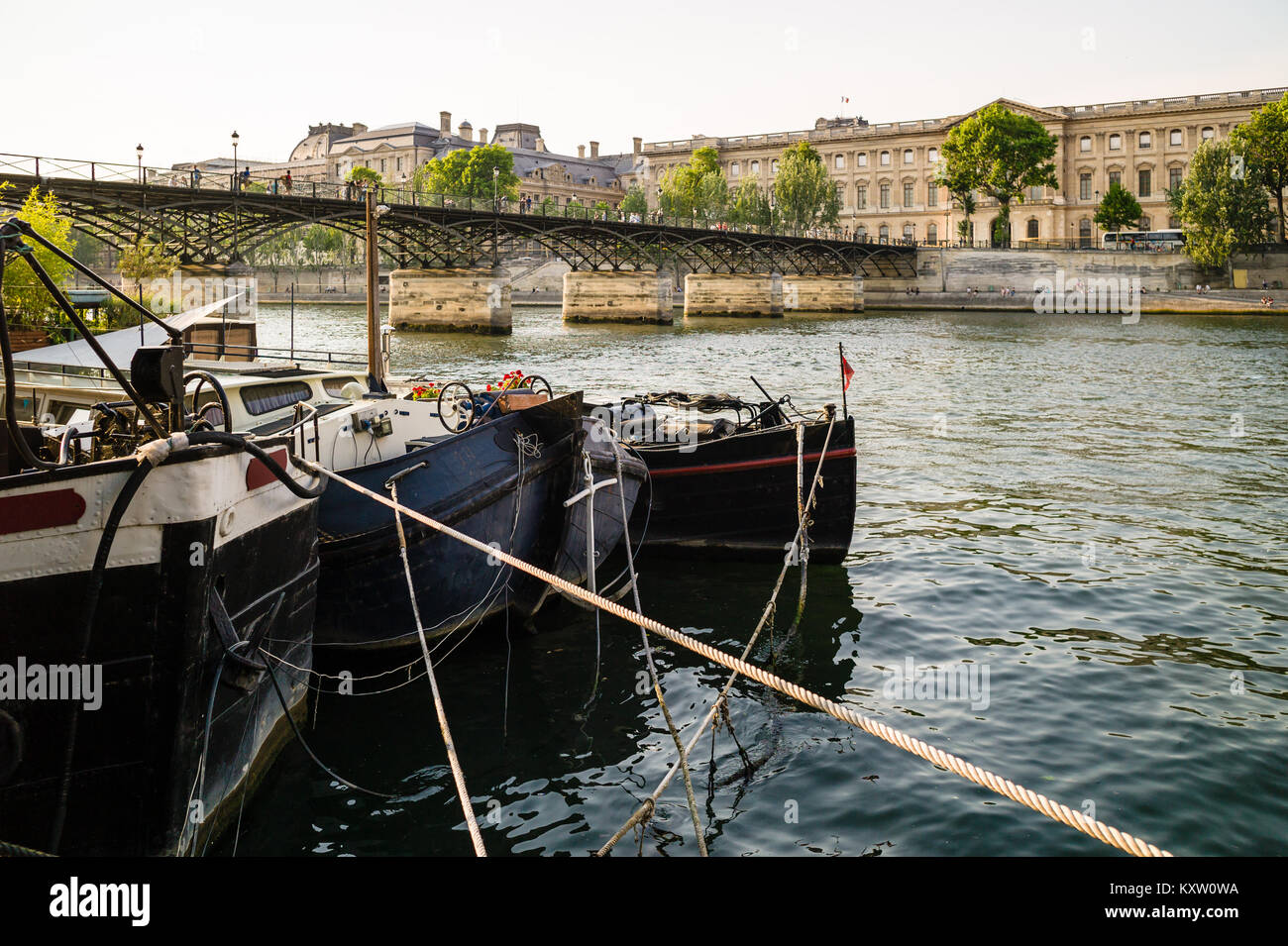 Der Pont des Arts, die Fußgängerbrücke über die Seine, der Louvre, im Zentrum von Paris, mit Hausbooten in den Vordergrund. Stockfoto