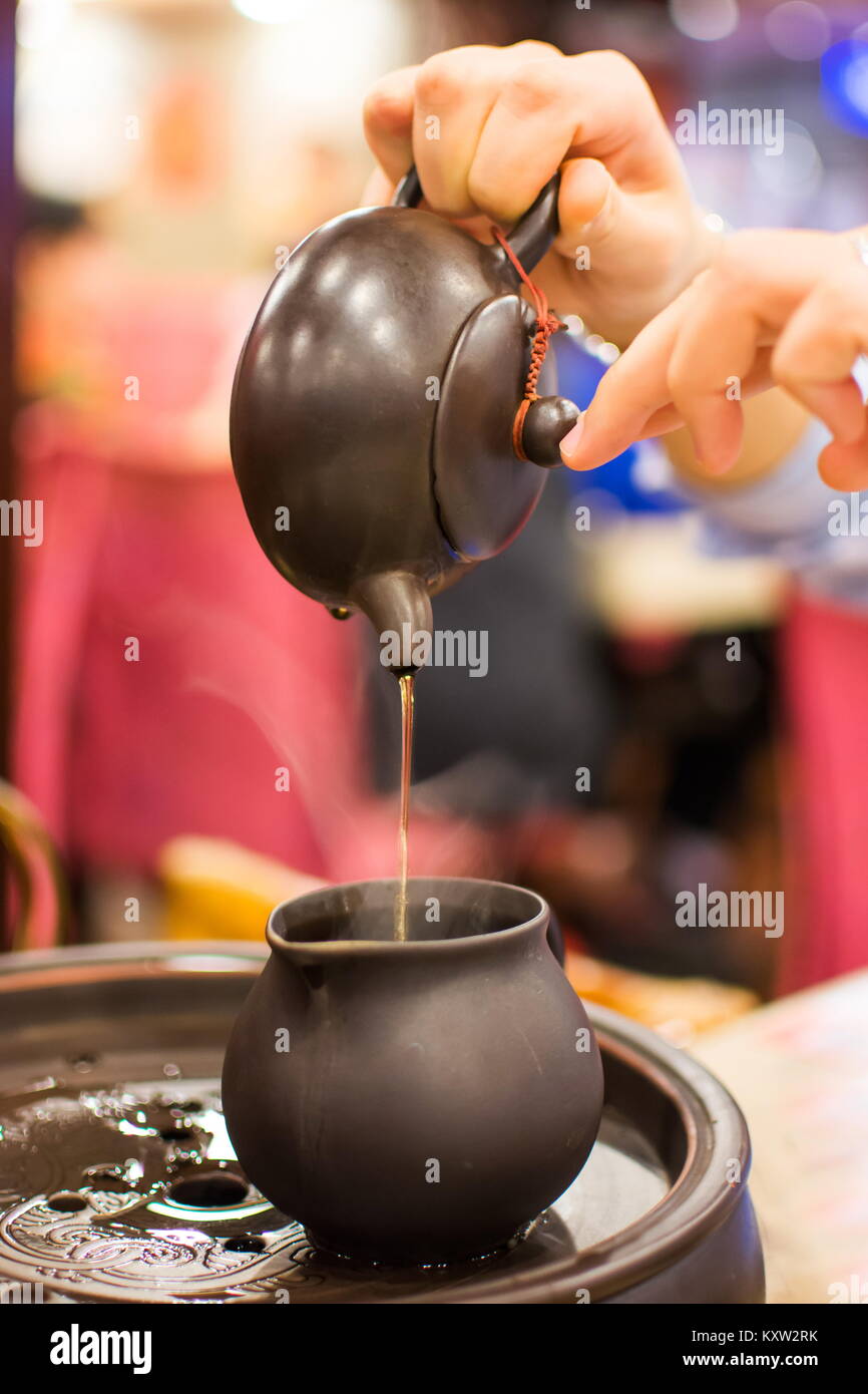 Weibliche hand gießt Tee Tee im Restaurant Stockfoto