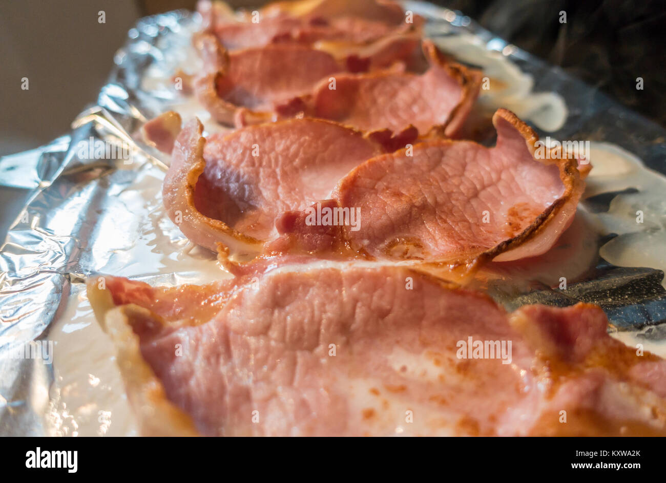 Gegrilltes, gekochtem Schinken auf Alufolie auf einer Grillpfanne. Stockfoto