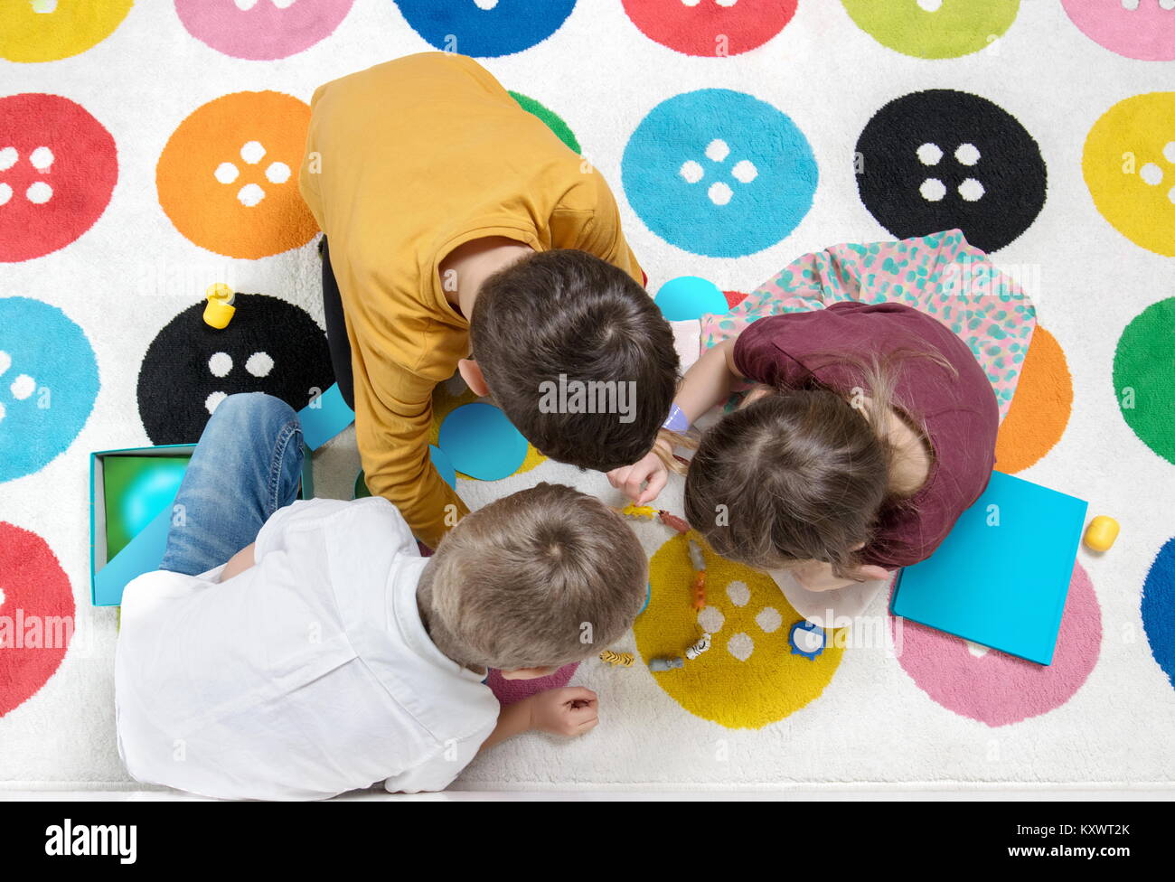 Kinder spielen zusammen mit einem Spiel auf dem Teppich und gemeinsam Spaß haben Stockfoto