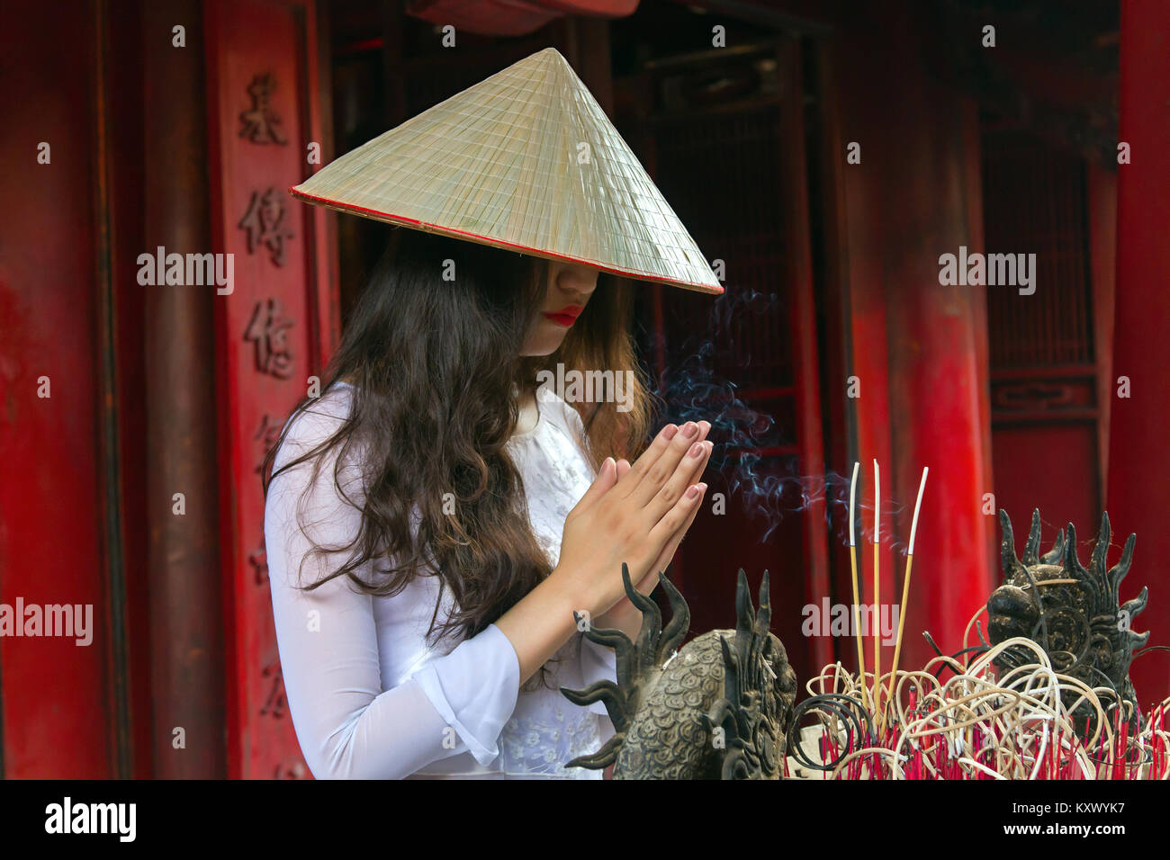 Junge vietnamesische Frau im Tempel der Literatur, Hanoi, Vietnam. Sie trägt den traditionellen Ao Dai Kleid. Stockfoto