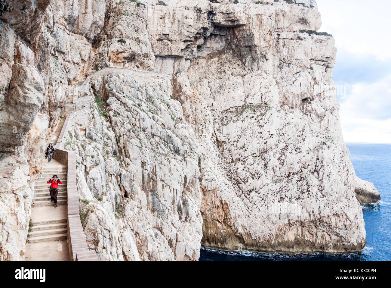 Zwei Frauen gehen auf Treppe inmitten von Capo Caccia Klippen. Alghero, Sardinien. Italien Stockfoto