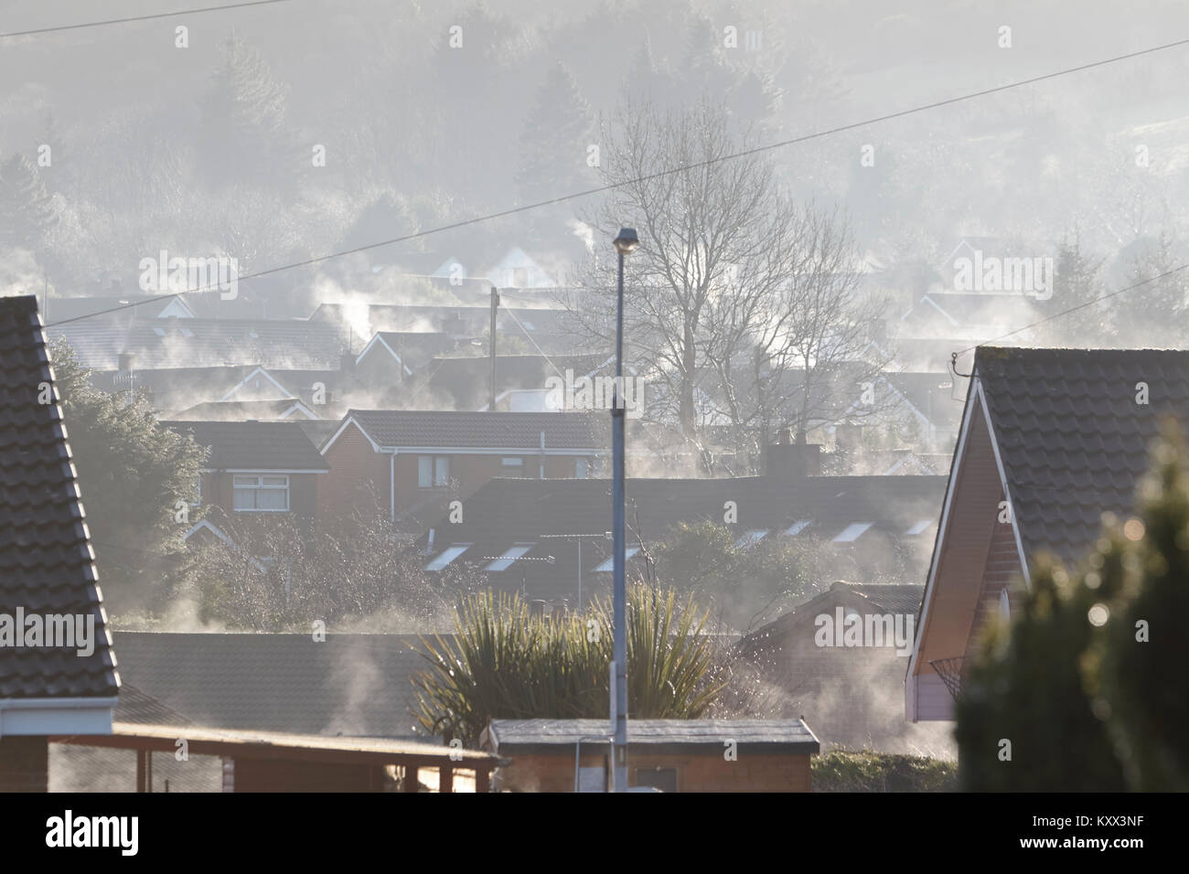Dampf stieg von Gebäuden, die Sonne brennt aus Nebel auf nebligen Tag in Großbritannien Stockfoto