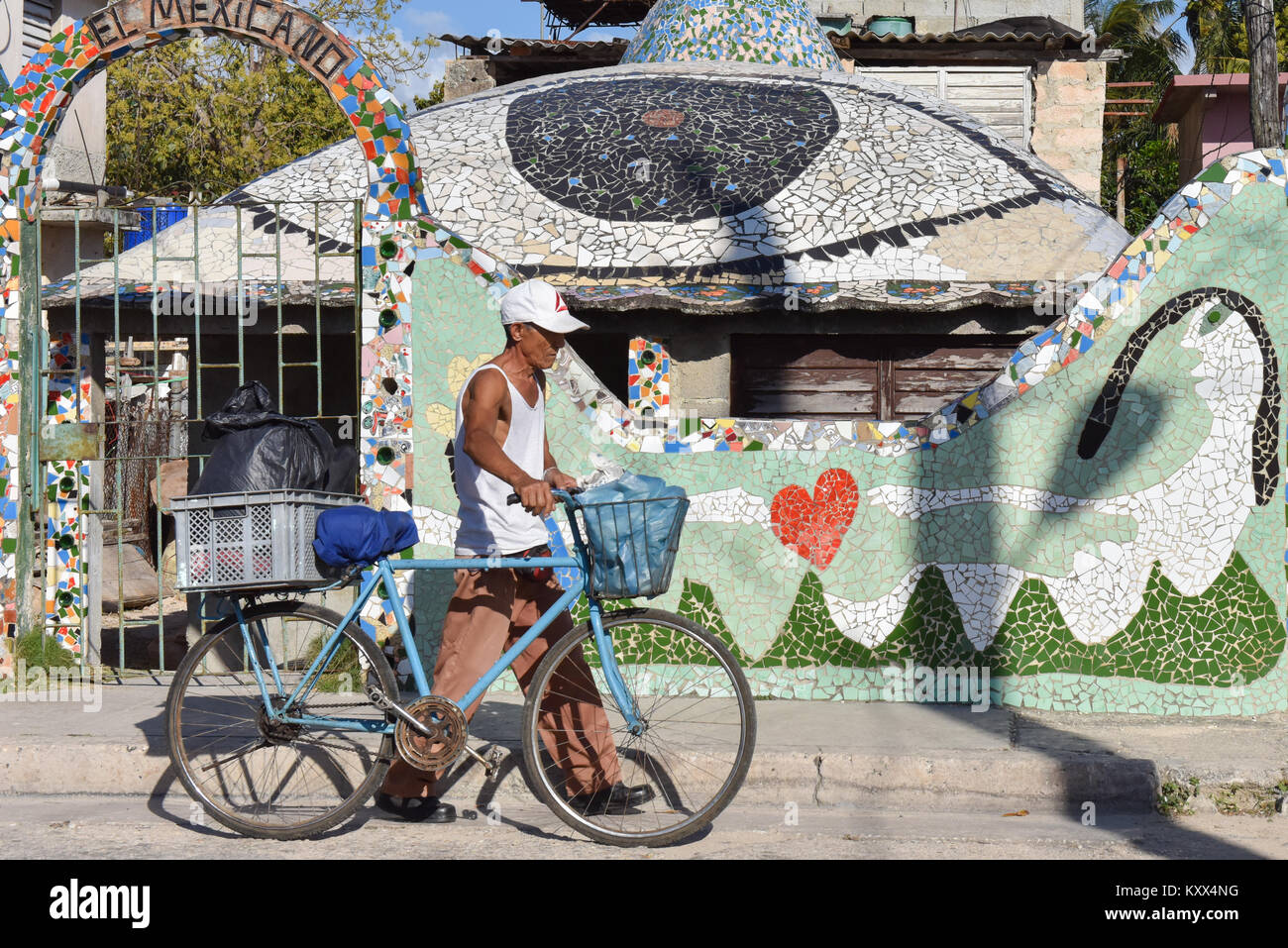 Der Mensch und sein Fahrrad zu Fuß neben Fusterlandia, eine Kunst, komplex, der nach seinem Schöpfer Jose Fuster. Es ist in Jaimanitas, einer strukturschwachen Gegend in der Nähe von Havanna Kuba etablierten genannt wurde. Stockfoto