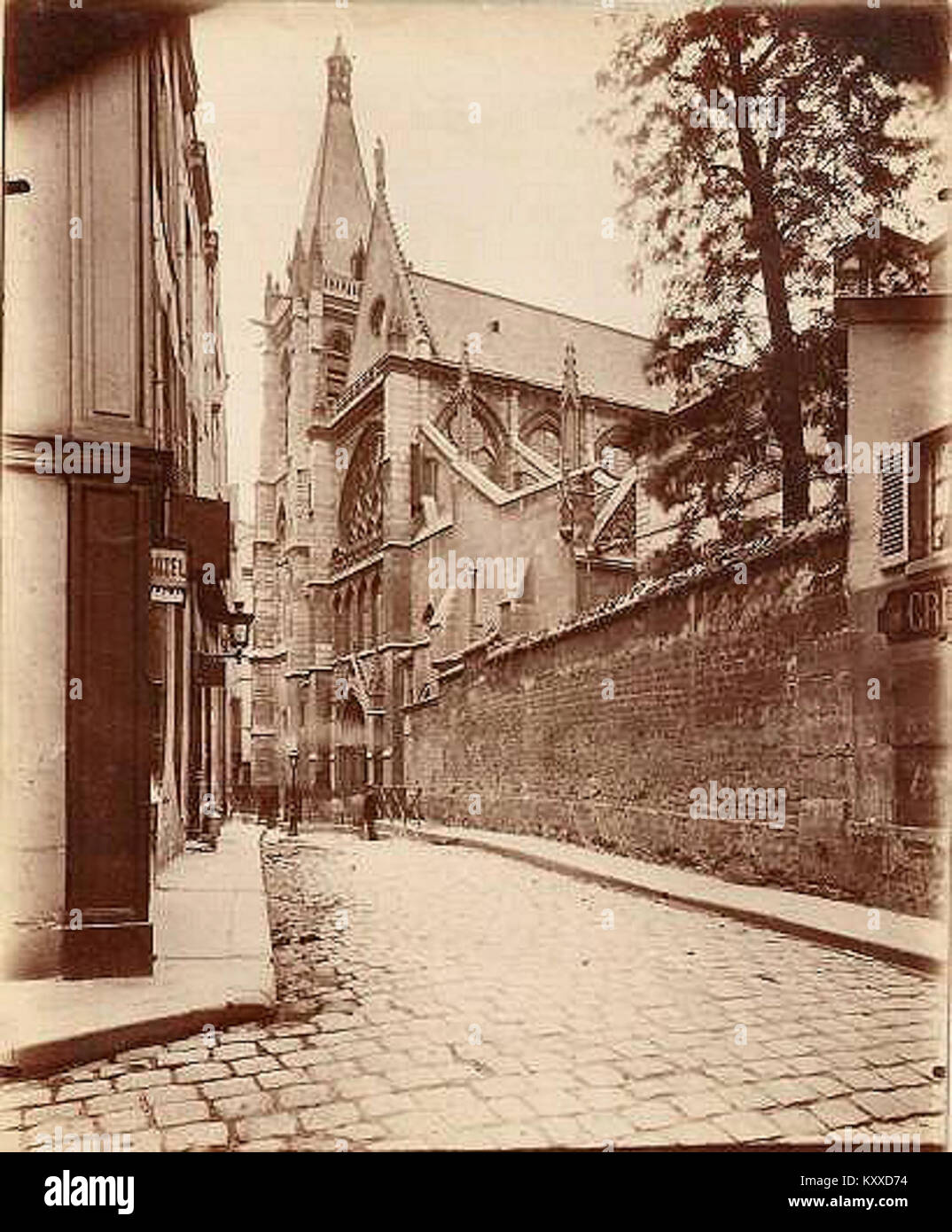 Diese Fotografie von Eugène Atget mit dem Titel „Rue des Prêtres-Saint-Séverin“ (Paris, 5. Arrondissement) zeigt eine enge Straße im Quartier Latin, mit der Fassade der Kirche Saint-Séverin am anderen Ende sichtbar ist, Kopfsteinpflaster und Ladenfronten, die Teil von Atgets Arbeiten sind, die Pariser Straßenlandschaften um 1898 dokumentieren. Stockfoto
