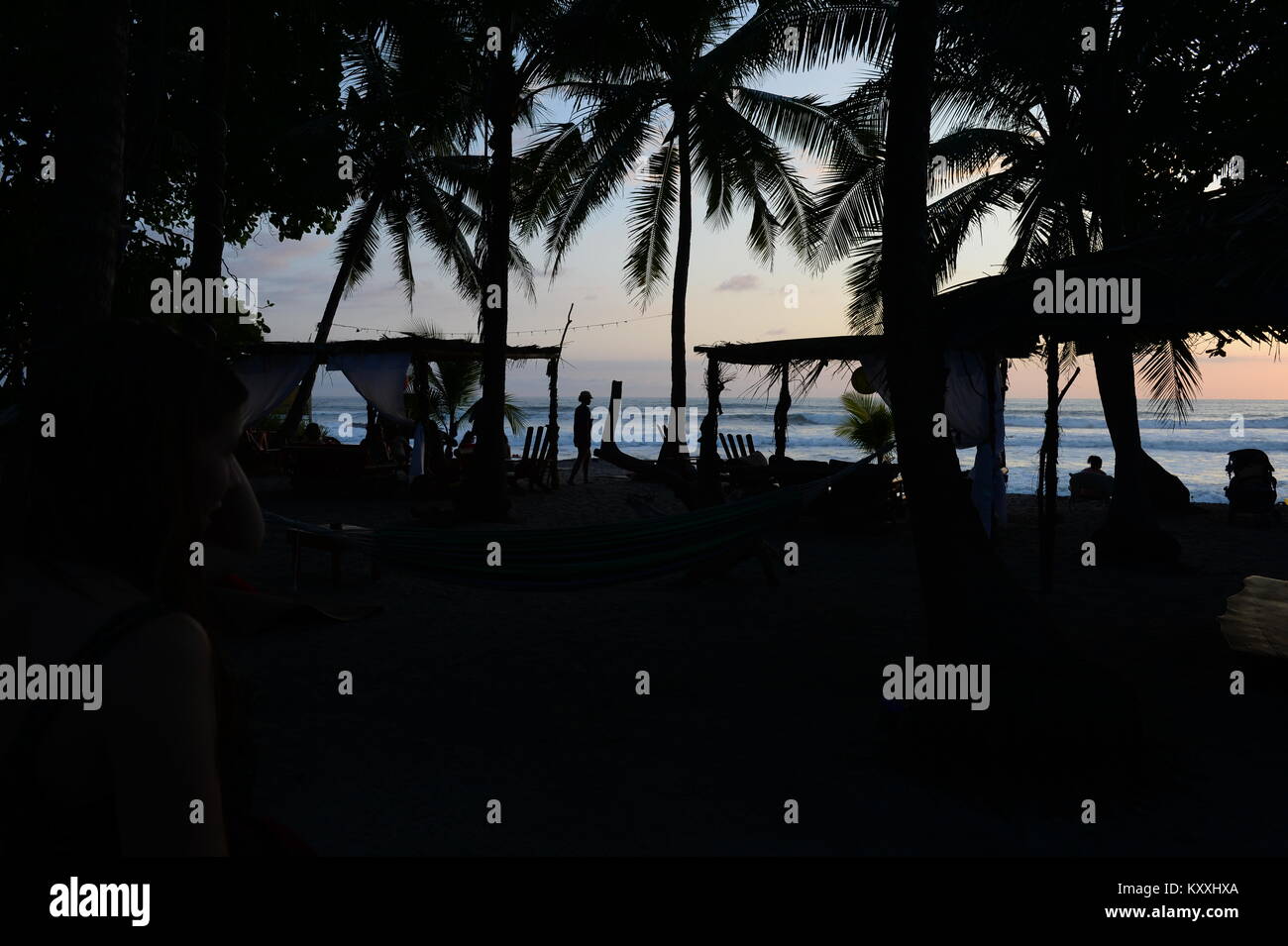 Die Leute, um den Sonnenuntergang von Santa Teresa, die weltweit berühmt ist zu genießen. Kokospalmen stark gegen den Abendhimmel. Stockfoto