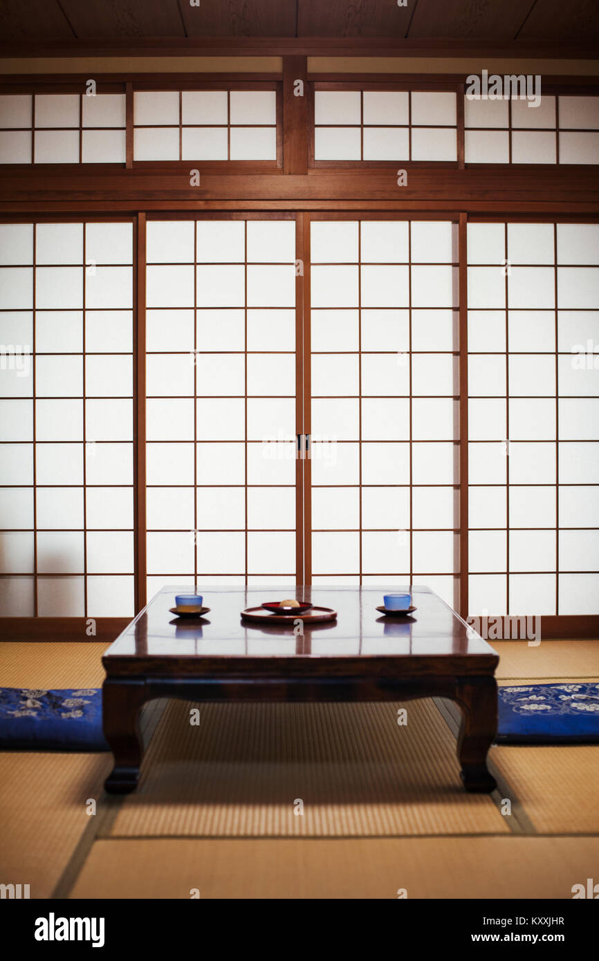 Traditionelle japanische Interieur mit niedriger Tisch mit Schüsseln Tee. Stockfoto