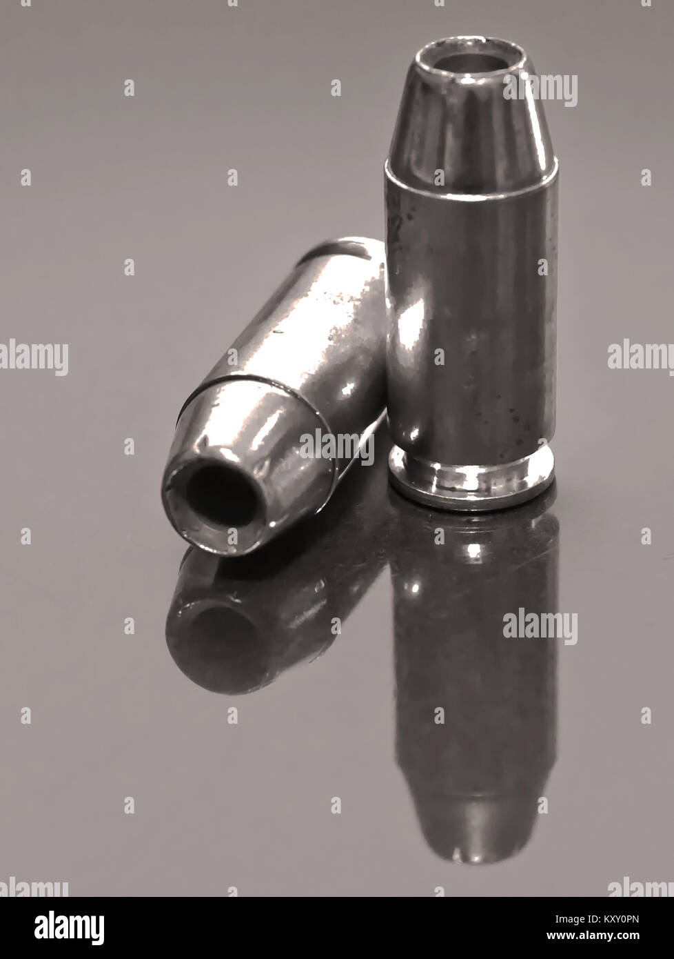 Zwei 9-mm-hohlwelle Punkt Kugeln mit ihren Reflexionen auf einer Glasoberfläche in Schwarz und Weiß Stockfoto
