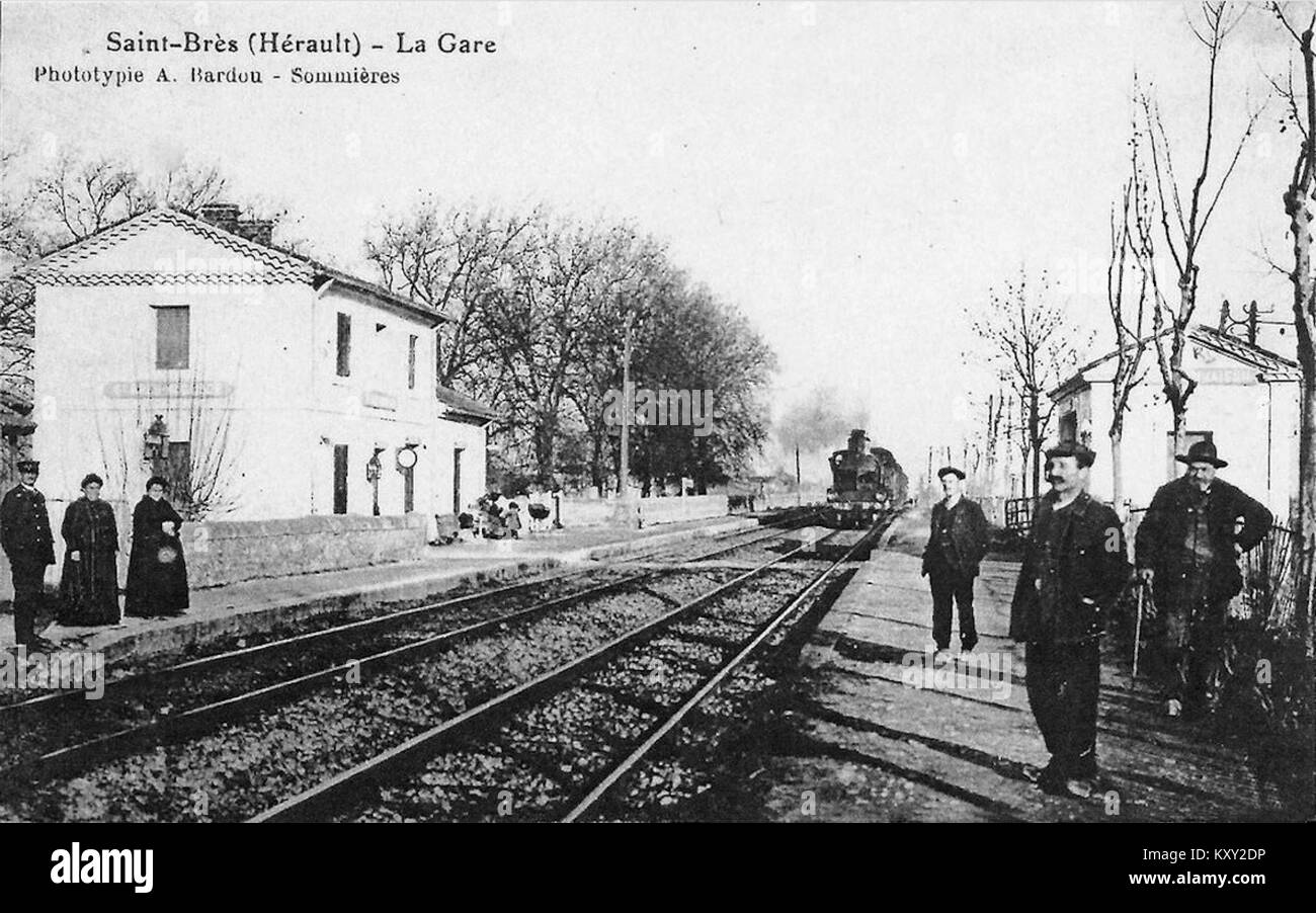 Der Bahnhof Gare Saint-Brès, 1900 erfasst, zeigt Bahnhofseinrichtungen, Bahnsteige, Gleise, und die nahe gelegene Stadtlandschaft in Frankreich. Stockfoto