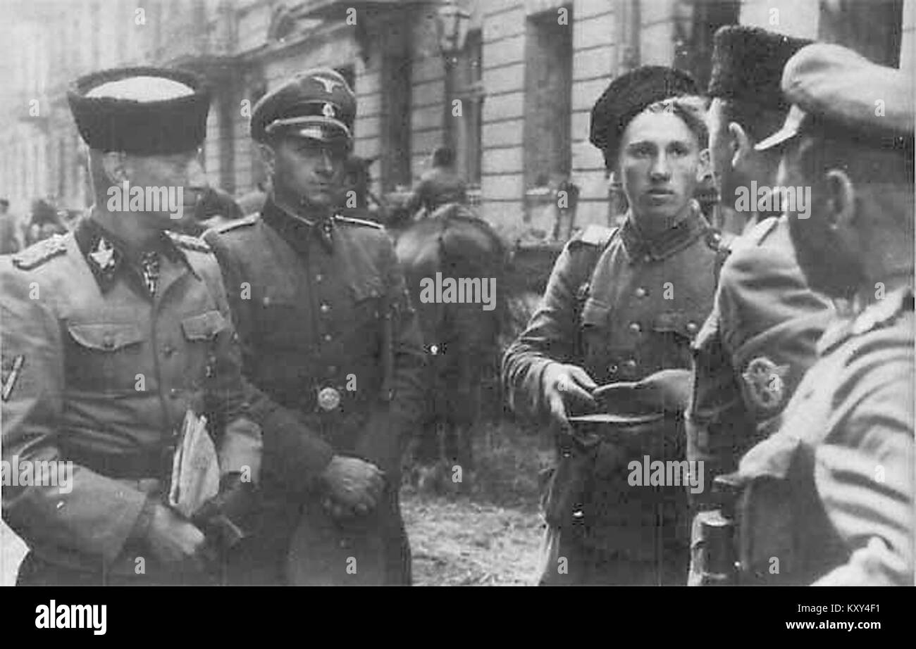 Foto von General Heinz Reinefarth mit Kubanka-Hut neben Mitgliedern des 3. Kosakenregiments. Das Bild zeigt eine Szene aus der Zeit des Zweiten Weltkriegs, an der deutsche und kosakische Militärangehörige beteiligt waren. Stockfoto