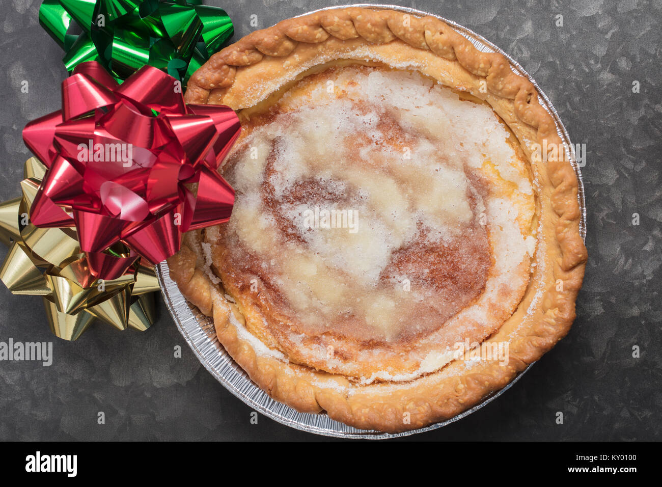 Süße Vanillepudding Karamell Kuchen in der Dose durch Weihnachten Schleifen an einem Metallauflagefach umgeben Stockfoto