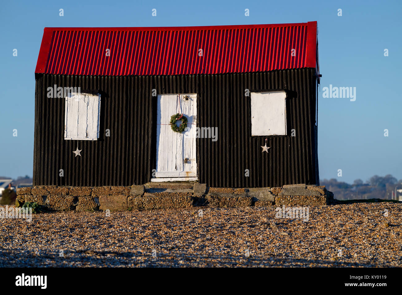 Weihnachten Kranz ist auf der weißen Tür der schwarzen und roten Hütte in Roggen Hafen platziert. Stockfoto