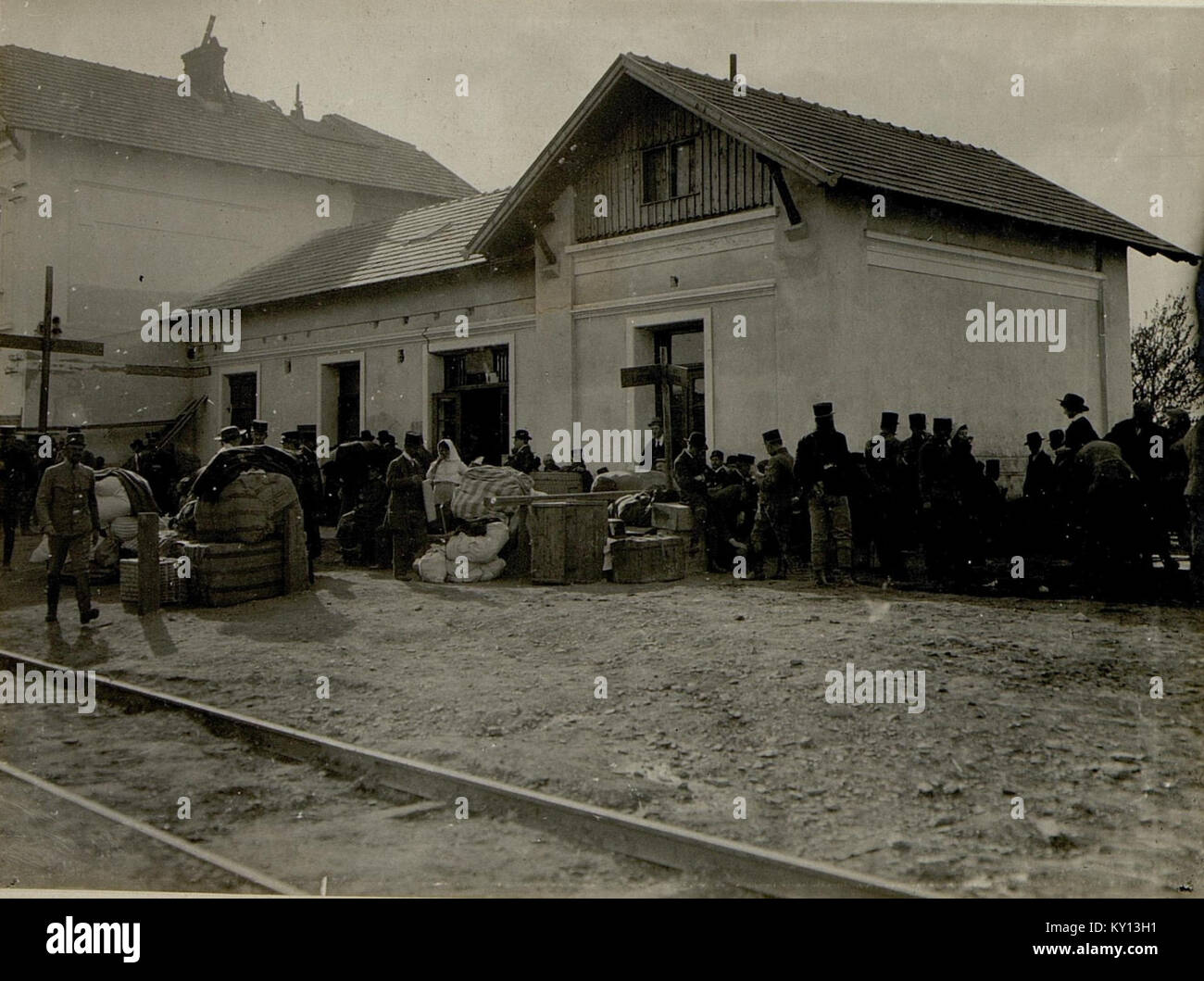 Dieses historische Foto zeigt Flüchtlinge am Bahnhof in Podhajce, die einen bedeutenden Moment während einer Vertreibung festhalten. Das Bild spiegelt den menschlichen Aspekt der Migration und die Herausforderungen wider, denen sich Flüchtlinge in dieser Zeit gegenübersahen. Stockfoto