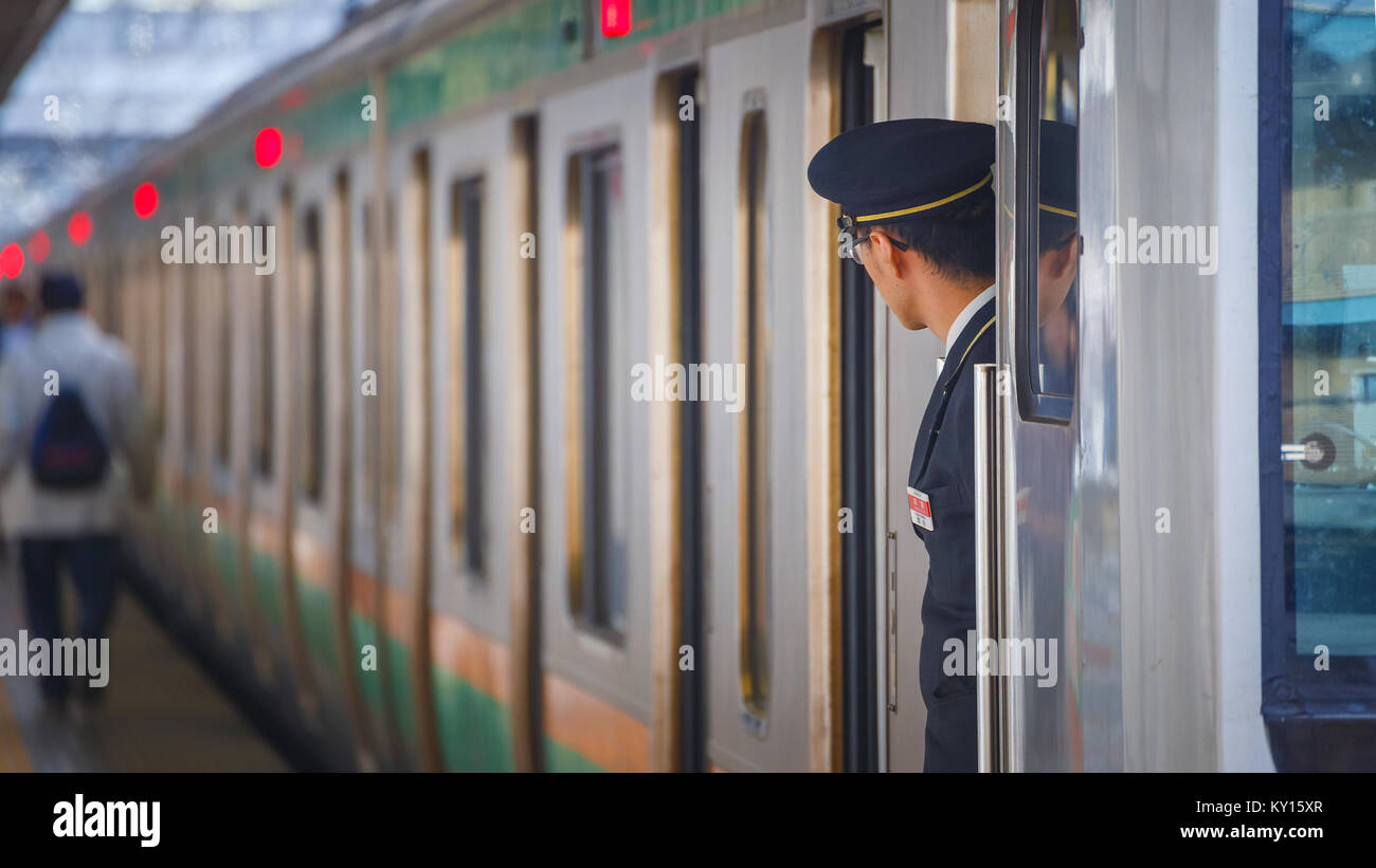 TOKYO, Japan - 29 November 2015: Ein nicht identifizierter Japanischen Zugbegleiter ist auf seine Pflicht auf einer Plattform an Ikebukuro Station Stockfoto