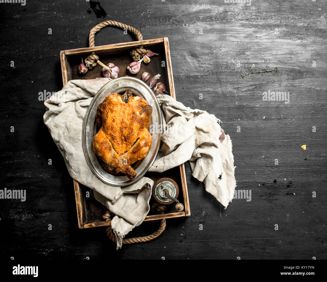 Gebratenes Huhn auf einem alten Fach auf der schwarzen Tafel. Stockfoto