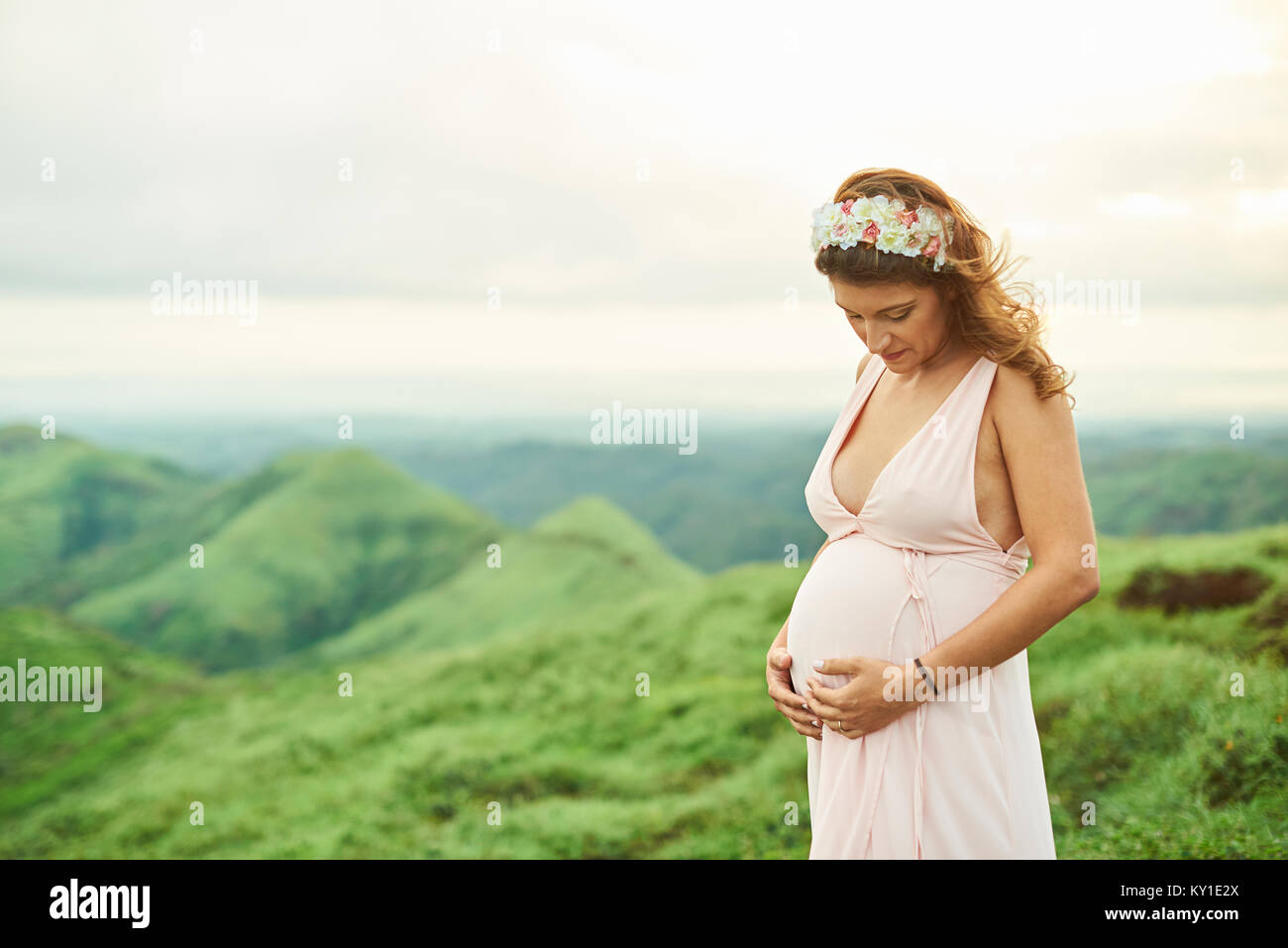 Schwangere Frau auf dem Bauch im freien Hintergrund Stockfoto