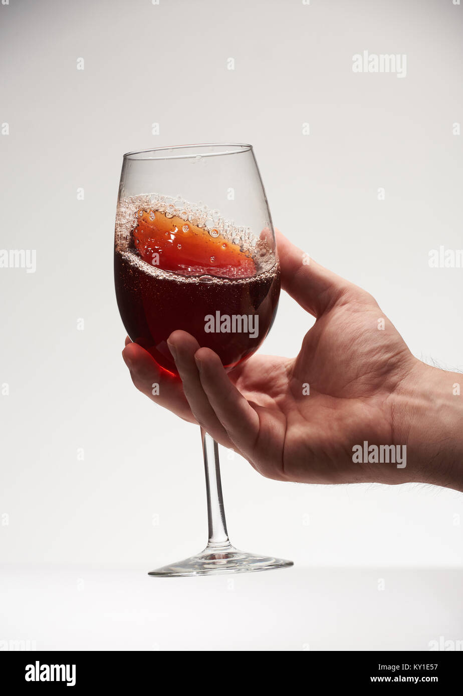 Rotwein mit Glanz in Glas auf weißem Hintergrund. Close-up Rotwein mit Blase Stockfoto